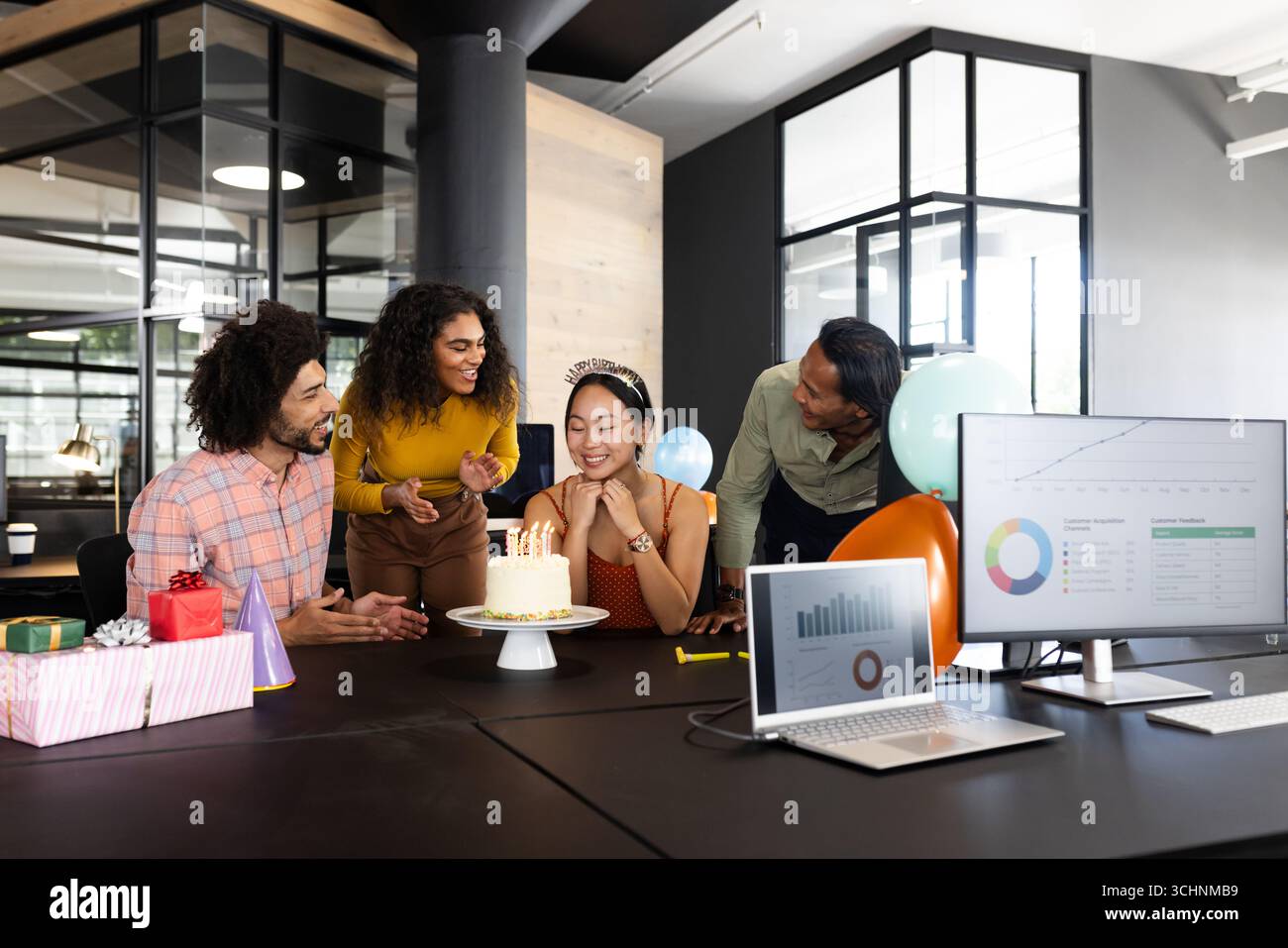 Diverse Kollegen feiern Geburtstag im modernen Büro mit Kuchen und Geschenken auf dem Tisch Stockfoto