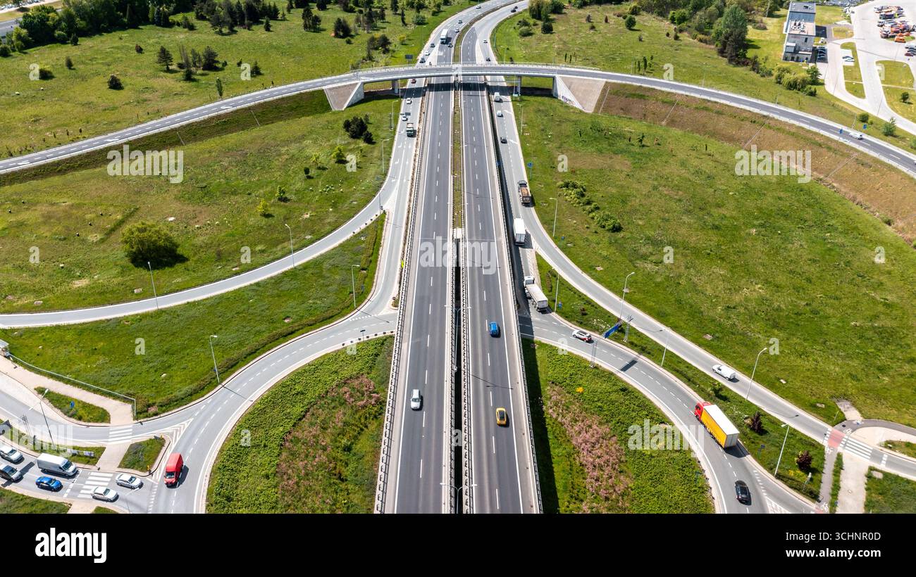 Autobahnkreuz mit Ringrampen und grüner Landschaft, die eine effiziente Verkehrsanordnung und ein effizientes Verkehrsdesign bietet Stockfoto