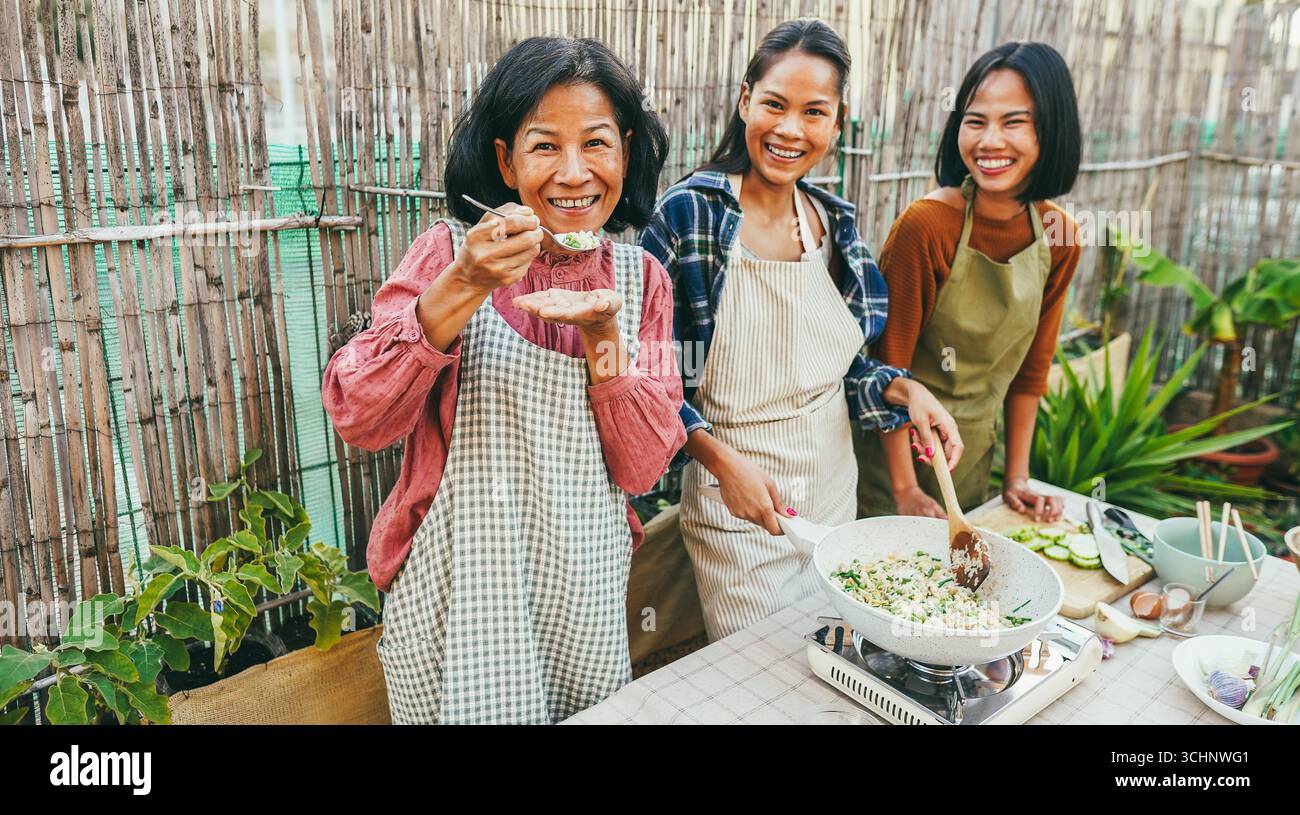 Asiatische Familienkost thailändisches Abendessen zu Hause Terrasse im Freien - Lifestyle und Food Konzept - Hauptfokus auf das Gesicht der Mutter Stockfoto