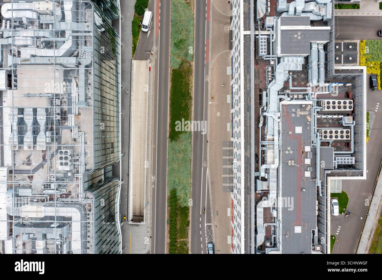 Blick auf die Stadt von oben auf die Straße, die von zwei Hightech-Gebäuden mit HLK-Anlagen auf dem Dach begrenzt wird Stockfoto