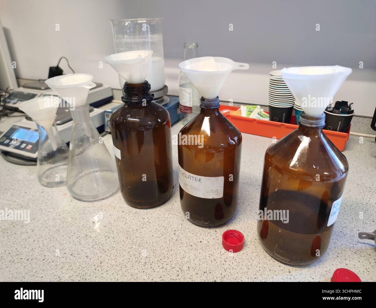 Flaschen mit Trichtern und Filtern zur Herstellung von Kalkwasser, für Experimente im naturwissenschaftlichen Unterricht an der Sekundarschule Stockfoto