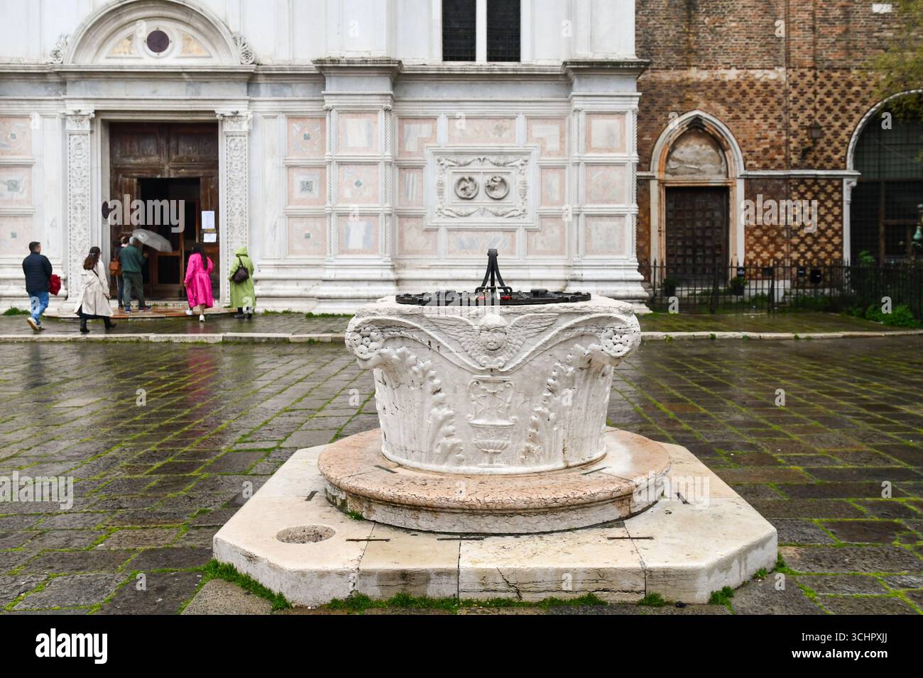 Antiker Brunnen (Vera da pozzo) aus istrischem Stein, mit einem Basrelief, das einen Cherub darstellt, vor der Kirche San Zaccaria (15. Jh.), Venedig, Italien Stockfoto