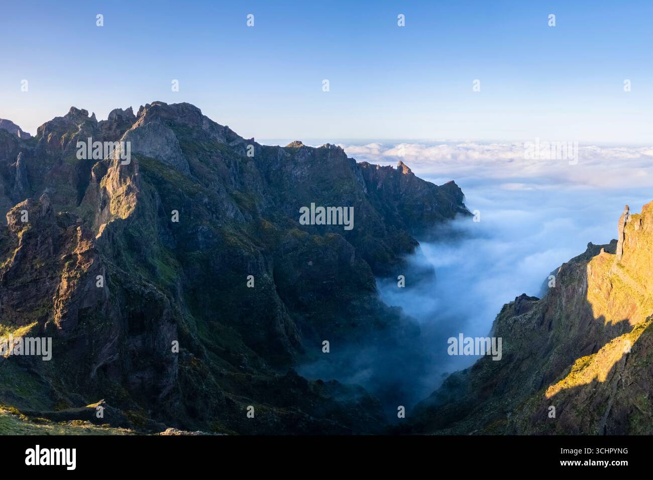 Blick aus der Vogelperspektive auf die Berge und Wanderwege, die während eines Sonnenuntergangs im Frühling zum Pico Pico do Arieiro führen. Insel Madeira, Portugal. Stockfoto