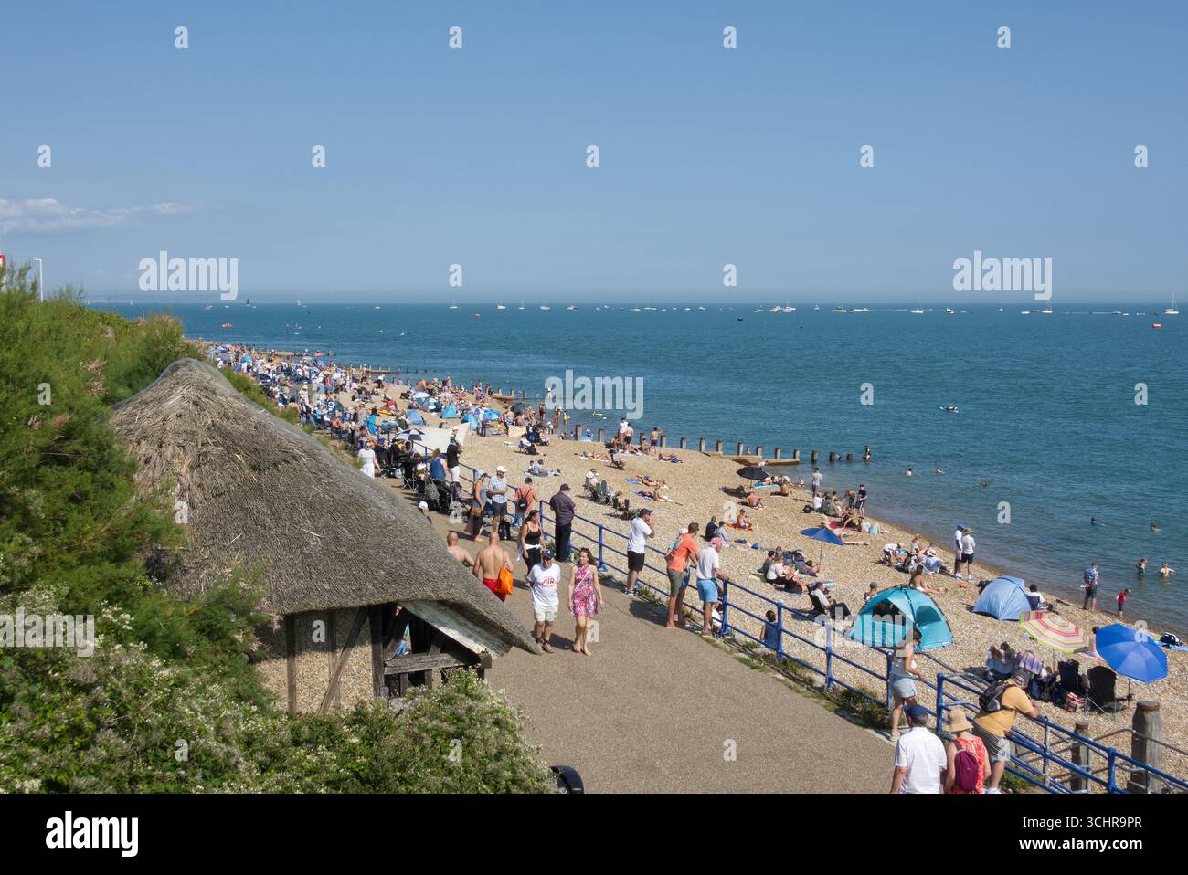 Strand und Promenade in Eastbourne in East Sussex, England. Große Menschenmassen am Strand und im Meer, die auf die Flugshow warten. Stockfoto