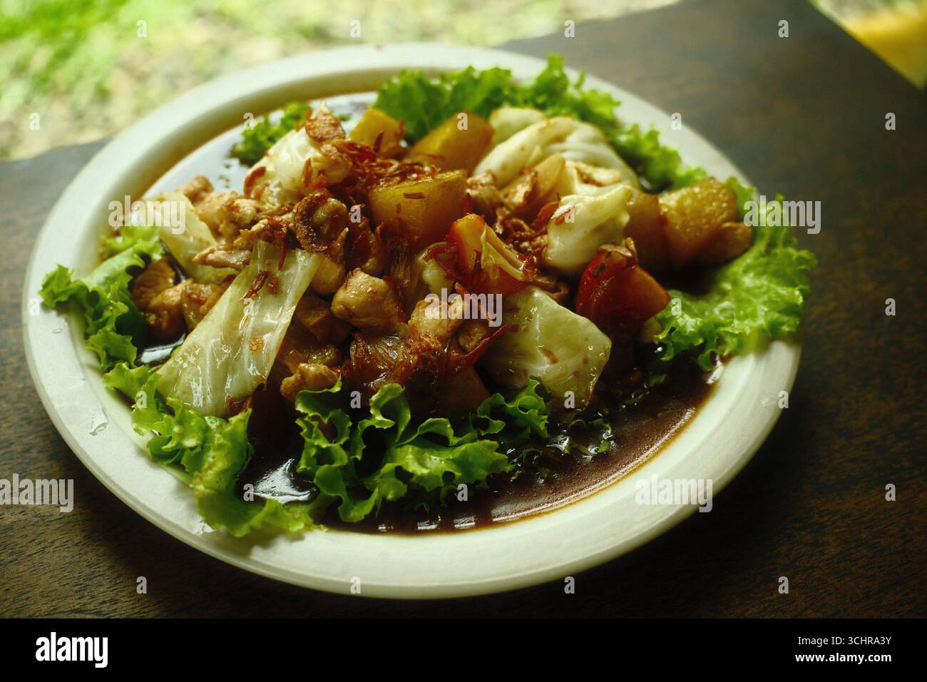 Ein Teller mit traditionellem gebratenem Hühnchen und Kartoffelgericht mit süßer Sojasauce und Salat Stockfoto