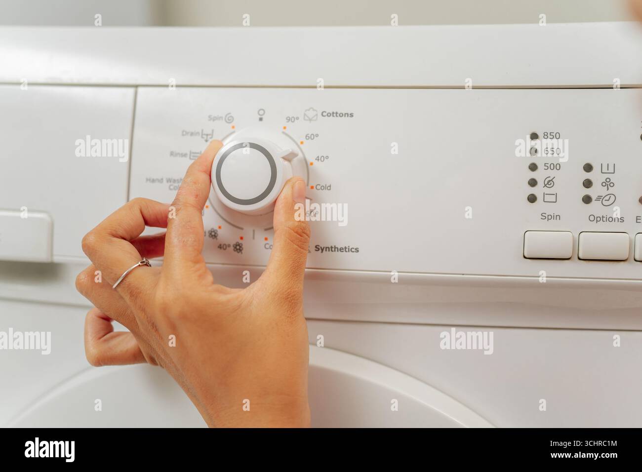 Korrekte Anpassung der Waschmaschineneinstellungen, um eine optimale Wäschepflege zu gewährleisten Stockfoto