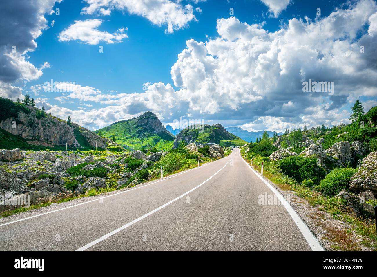 Malerische Bergstraße am Valparolapass im UNESCO-Weltkulturerbe Dolomiten, Südtirol Italien mit dramatischen Berggipfeln und blauem Himmel mit weißem c Stockfoto
