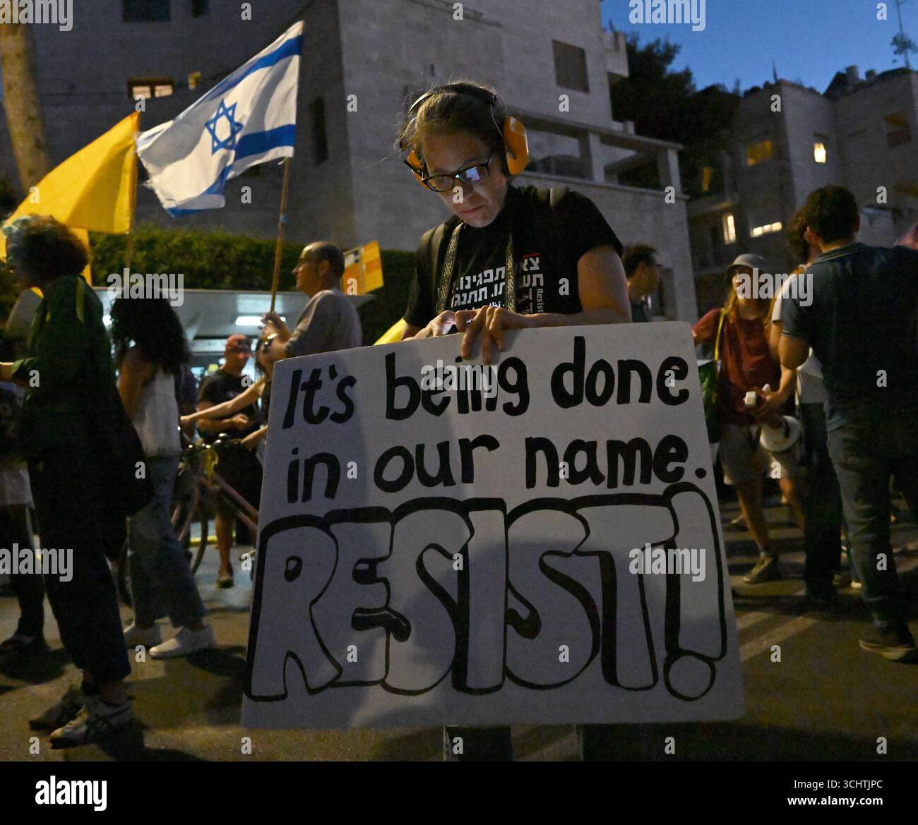 Jerusalem, Israel. September 2025. Eine Frau hält ein handgeschriebenes Schild mit der Aufschrift "es wird in unserem Namen gemacht. WIDERSTEHEN!“ Bei einem Protest, der das Ende des Krieges und die Rückkehr der Geiseln auf dem Pariser Platz in der Nähe des offiziellen Wohnsitzes des israelischen Premierministers Benjamin Netanjahu in Jerusalem am Mittwoch, den 3. September 2025 forderte. US-Präsident Donald Trump forderte die Hamas auf, „SOFORT alle 20 Geiseln zurückzugeben“ in einem Beitrag auf Truth Social. Foto: Debbie Hill/ Credit: UPI/Alamy Live News Stockfoto