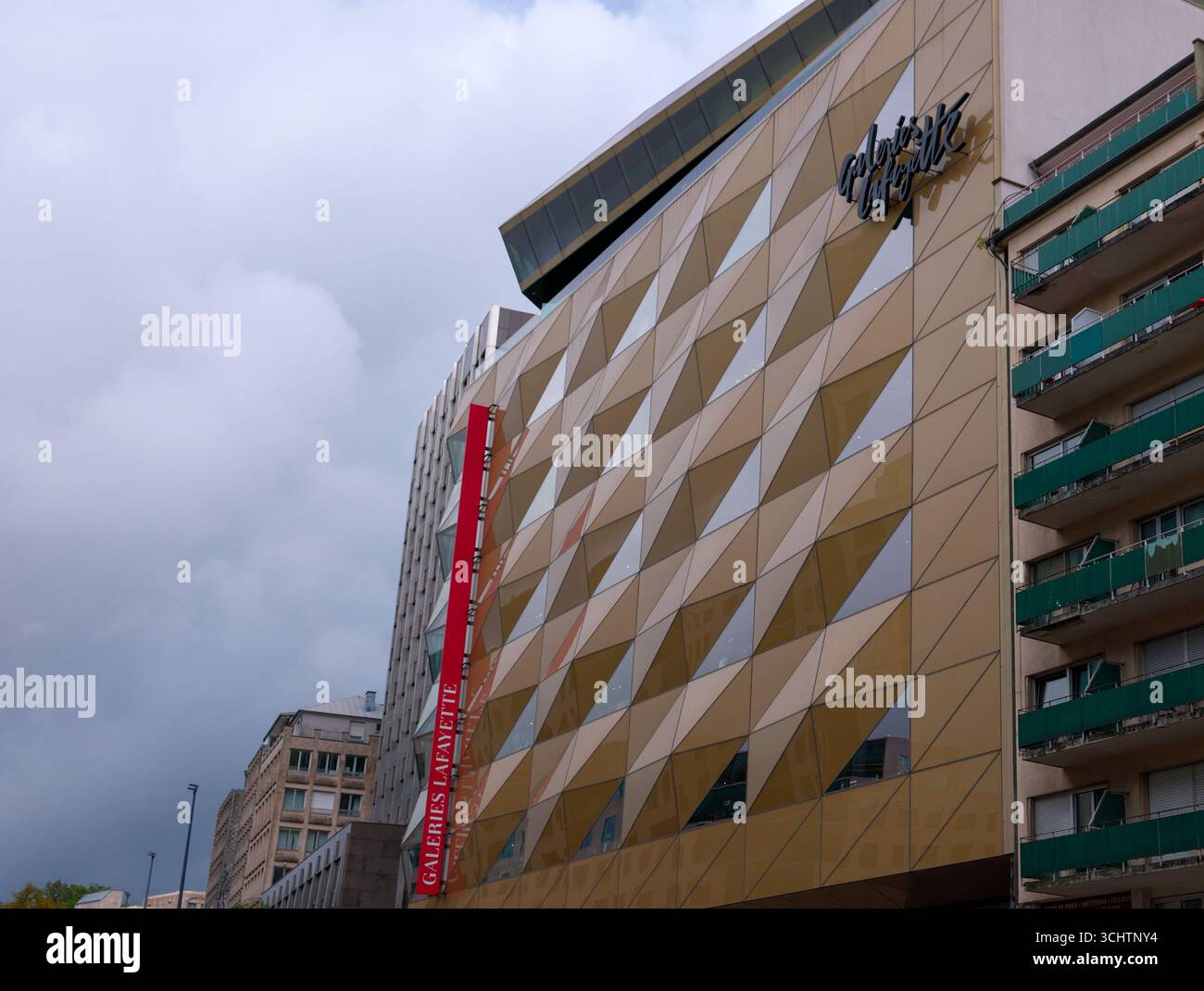 LUXEMBURG, EUROPA - 1. SEPTEMBER 2025 - Moderne Architektur des Kaufhauses Galeries Lafayette mit seiner dreieckigen Glasfassade, die die cl reflektiert Stockfoto