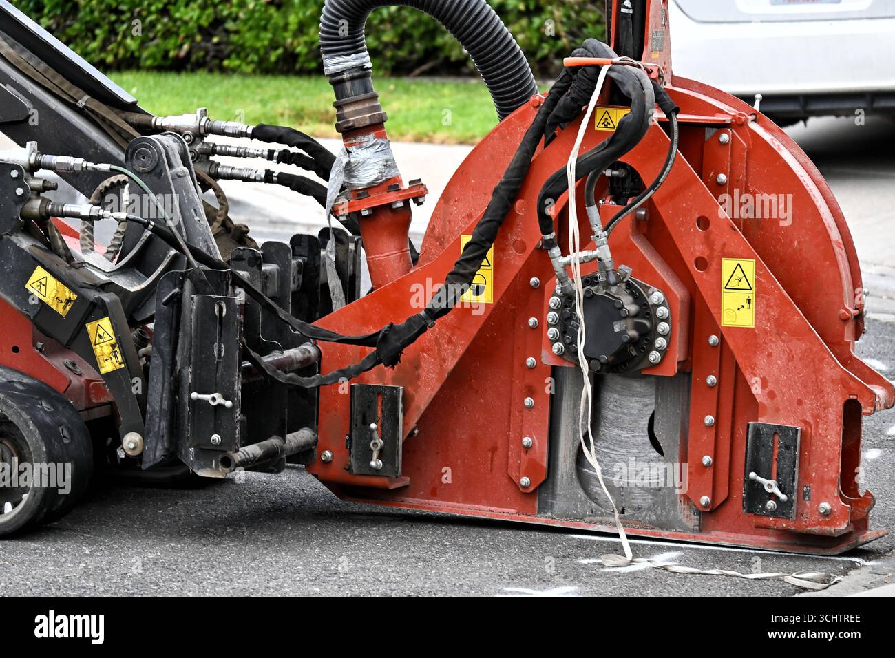 IRIVNE, KALIFORNIEN - 9. SEPTEMBER 2025: Nahaufnahme eines Grabenbrechers, der einen Graben für Glasfaserkabel in einer Wohngegend schneidet. Stockfoto