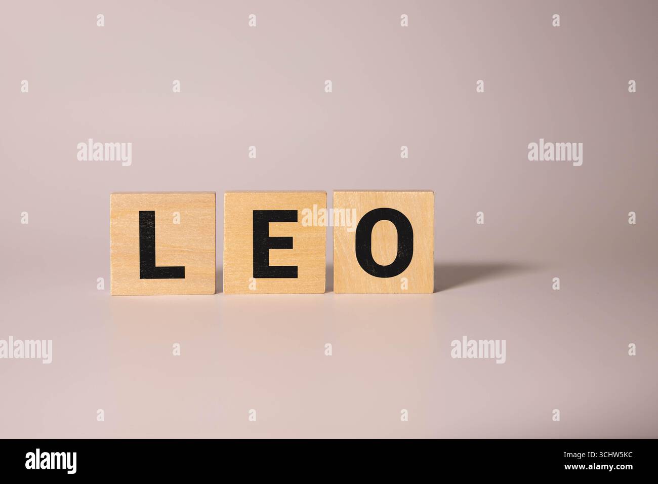 Der beliebte und moderne Name LEO für kleine Jungen in englischer Holzsprache Großbuchstaben, die aus einem Stapel von Buchstaben auf grünem Hintergrund in Sepia auslaufen Stockfoto