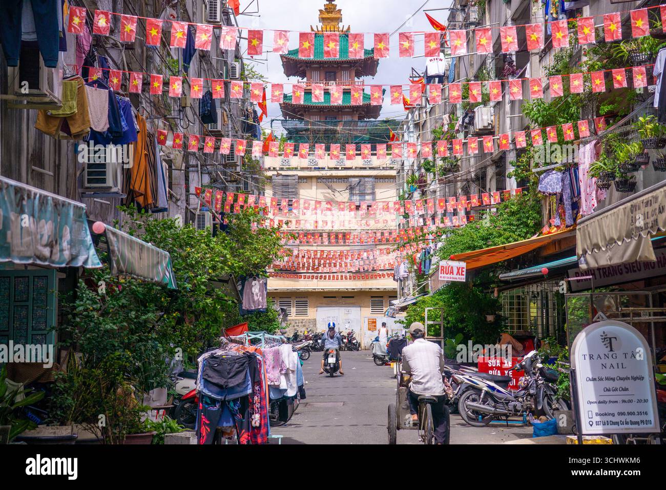 Ho-Chi-Minh-Stadt, Vietnam - 2. September 2025: Die vietnamesische Gasse ist mit Nationalflaggen und roten Bannern auf der Straße für die Feier des Vietnam-Nationalfeiertags dekoriert. V Stockfoto Ho-Chi-Minh-Stadt, Vietnam - 2. September 2025: Die vietnamesische Gasse ist mit Nationalflaggen und roten Bannern auf der Straße für die Feier des Vietnam-Nationalfeiertags dekoriert. V Stockfoto