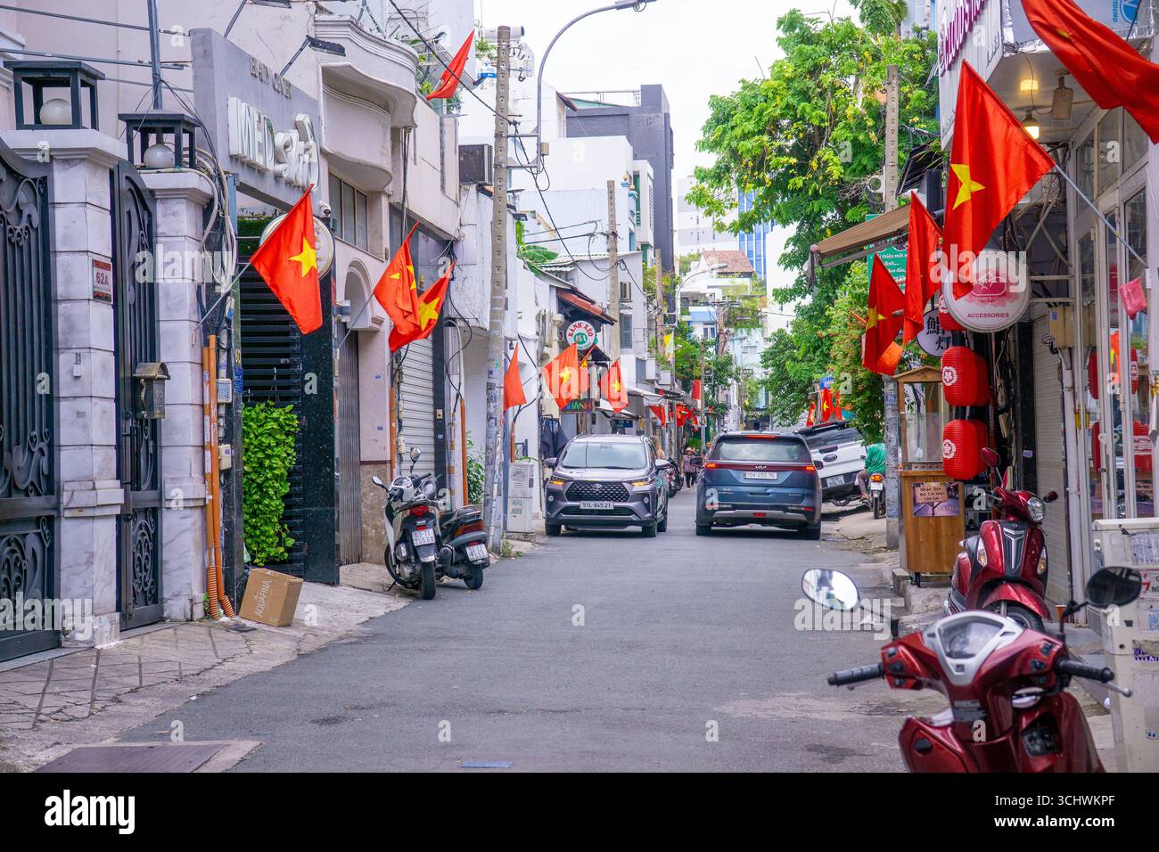 Ho-Chi-Minh-Stadt, Vietnam - 2. September 2025: Die vietnamesische Gasse ist mit Nationalflaggen und roten Bannern auf der Straße für die Feier des Vietnam-Nationalfeiertags dekoriert. V Stockfoto Ho-Chi-Minh-Stadt, Vietnam - 2. September 2025: Die vietnamesische Gasse ist mit Nationalflaggen und roten Bannern auf der Straße für die Feier des Vietnam-Nationalfeiertags dekoriert. V Stockfoto