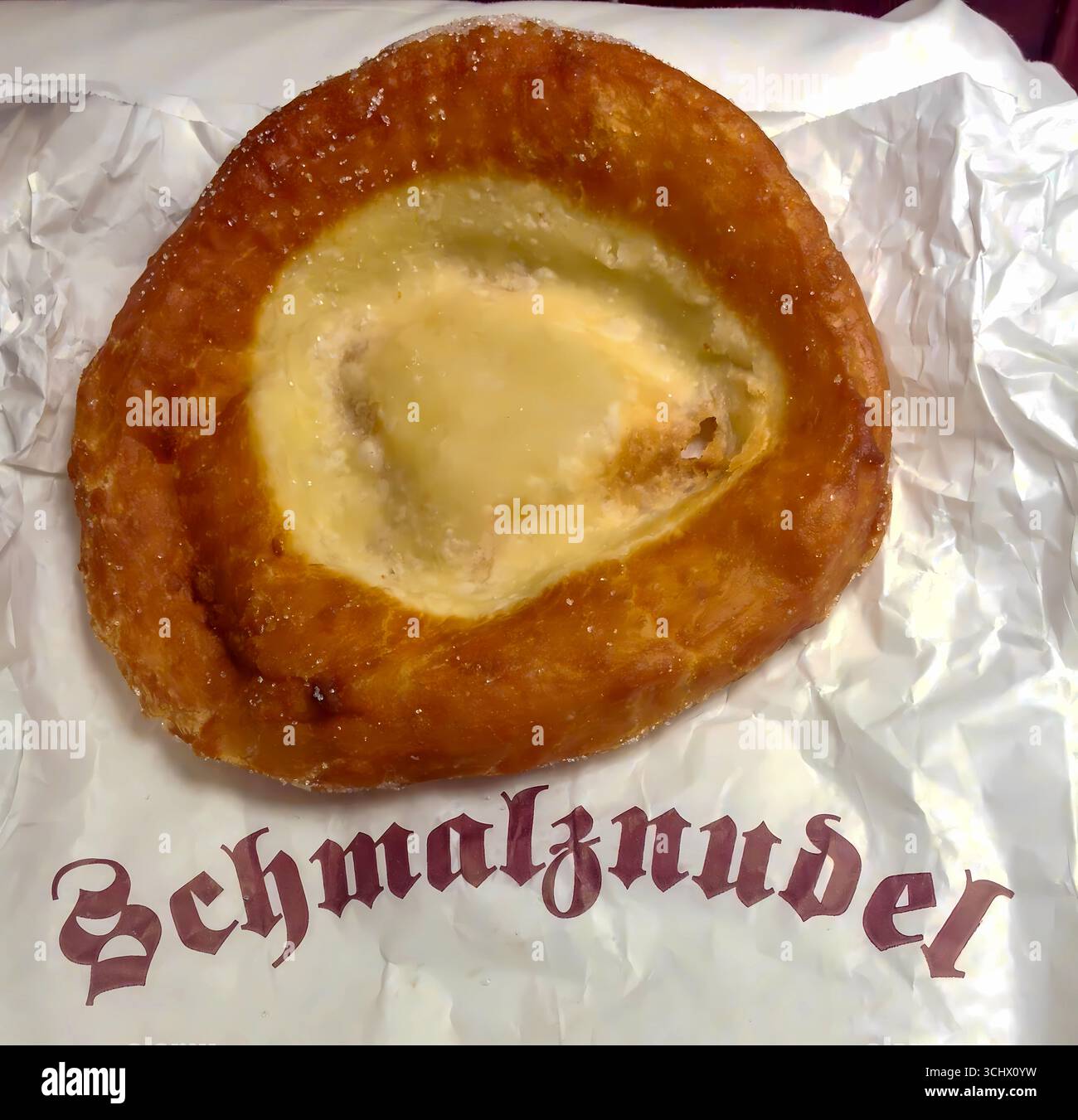 Traditionelle bayerische Schmalznudel, ein gebratenes Gebäck mit süßer Sahne, beliebt in Süddeutschland, insbesondere in der Umgebung Münchens. Stockfoto