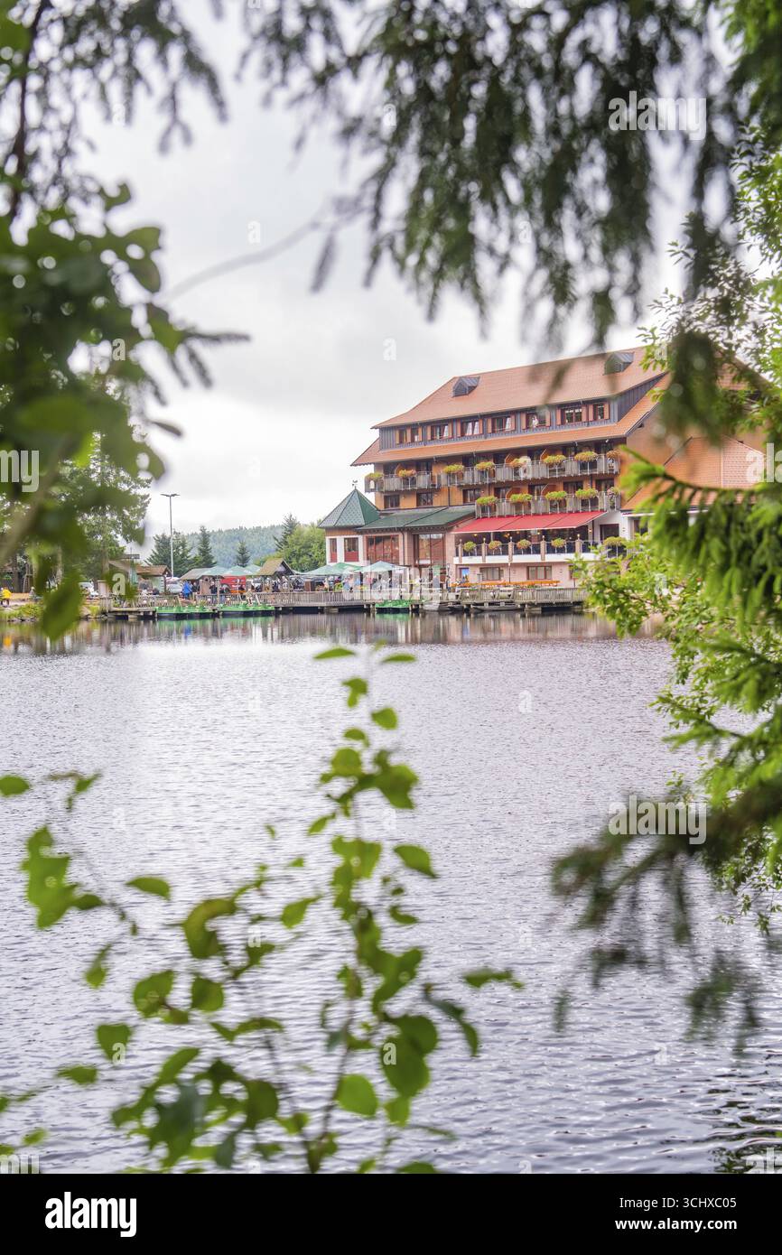 Gebäude mit Terrasse an einem ruhigen See, von Blättern eingerahmt, Mummelsee, Seebach, Ortenau, Schwarzwald, Deutschland Stockfoto