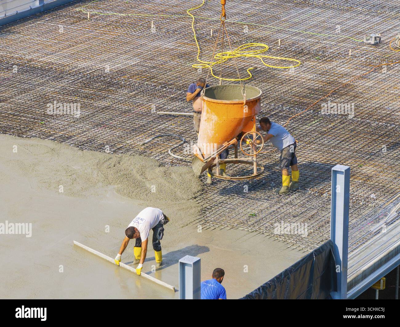 Nahaufnahme von Arbeitern, die auf einer Baustelle unter einem Kran betonieren, Parkplatzbau, Calw, Deutschland Stockfoto