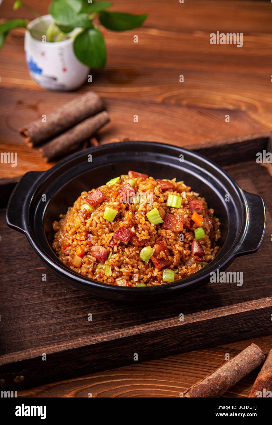 Amerikanischer Speck gebratener Reis im Tontopf auf Holztablett Stockfoto