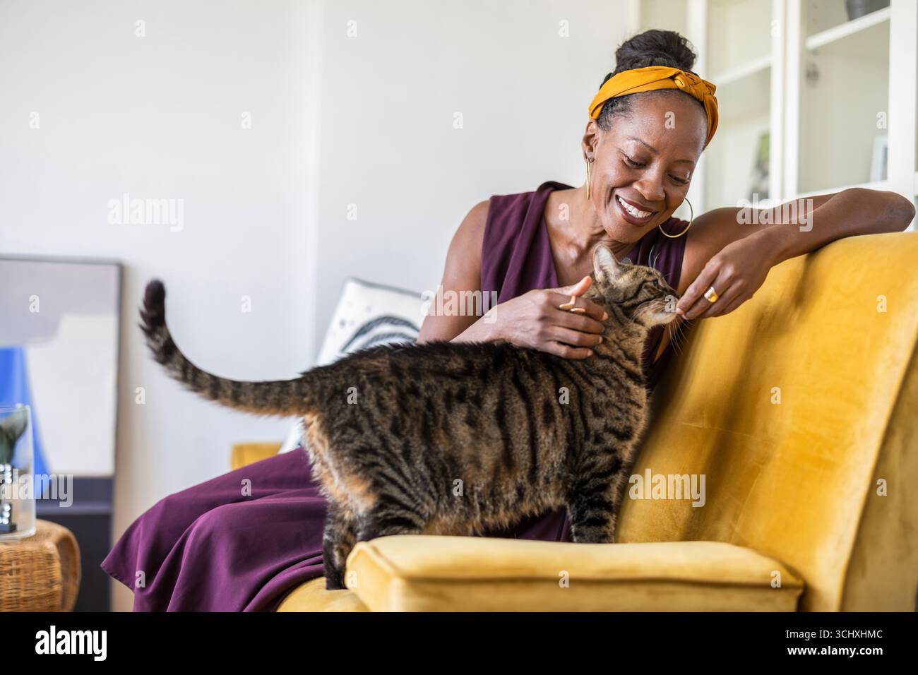 Porträt einer lächelnden Frau mit ihrer Katze zu Hause Stockfoto