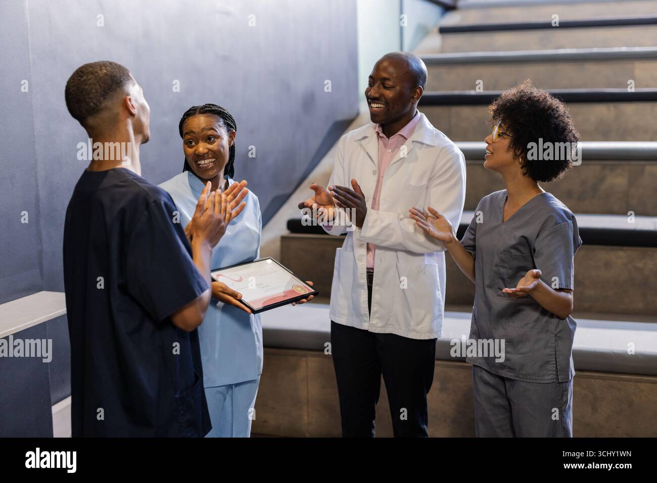 Feiern im Krankenhaus Treppenhaus, medizinisches Team klatscht für Kollegen erhält Auszeichnung Stockfoto