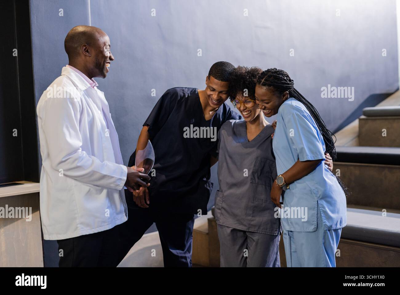 Gesundheitsfachkräfte in den Scrubs lachen zusammen während der Pause im Krankenhaus Stockfoto