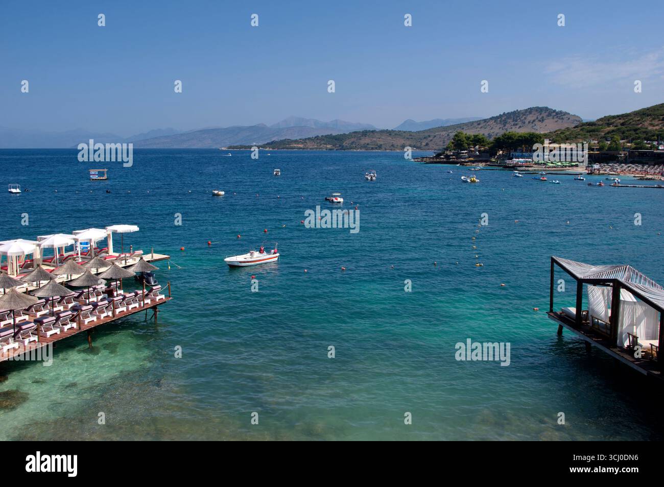 Pontile di prolungamento della spiaggia proteso sull'acqua limpida a Ksamil Stockfoto