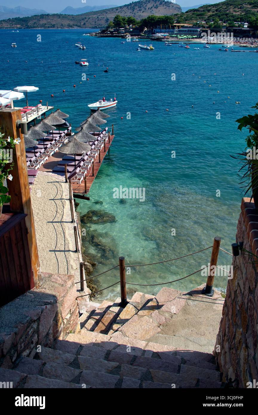 Pontile di prolungamento della spiaggia proteso sull'acqua limpida a Ksamil Stockfoto