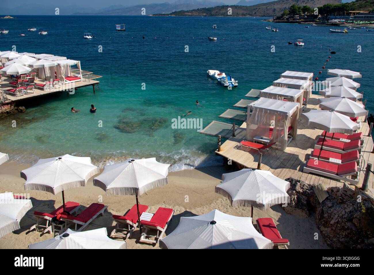 Pontile di prolungamento della spiaggia proteso sull'acqua limpida a Ksamil Stockfoto