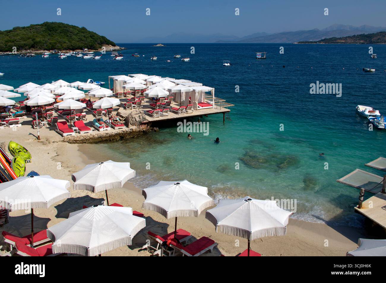 Pontile di prolungamento della spiaggia proteso sull'acqua limpida a Ksamil Stockfoto