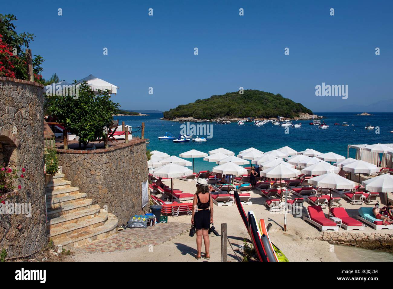 Ombrelloni su una spiaggetta di Ksamil contro il Mare trasparente ed azzurro Stockfoto