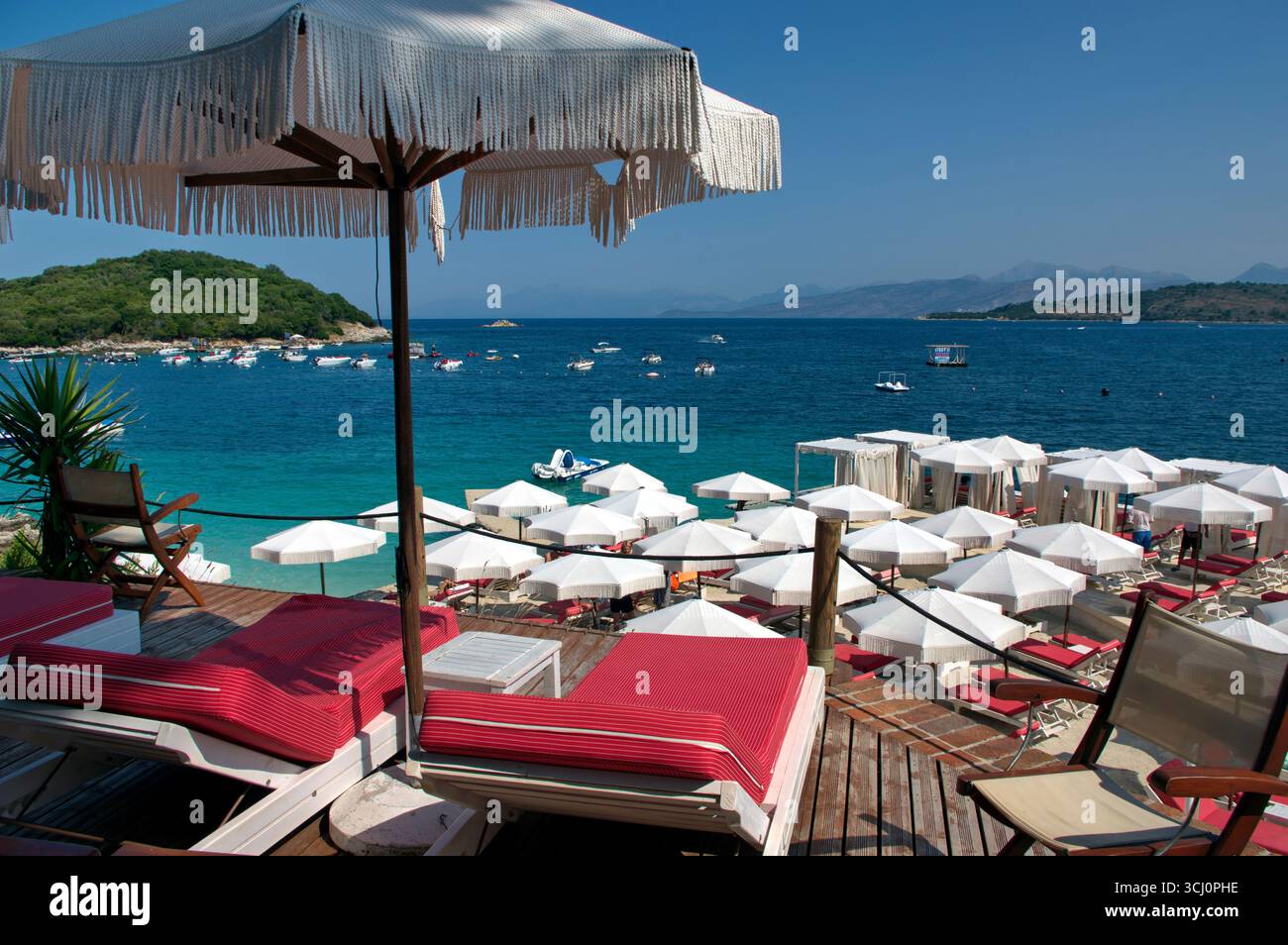 Pontile di prolungamento della spiaggia proteso sull'acqua limpida a Ksamil Stockfoto