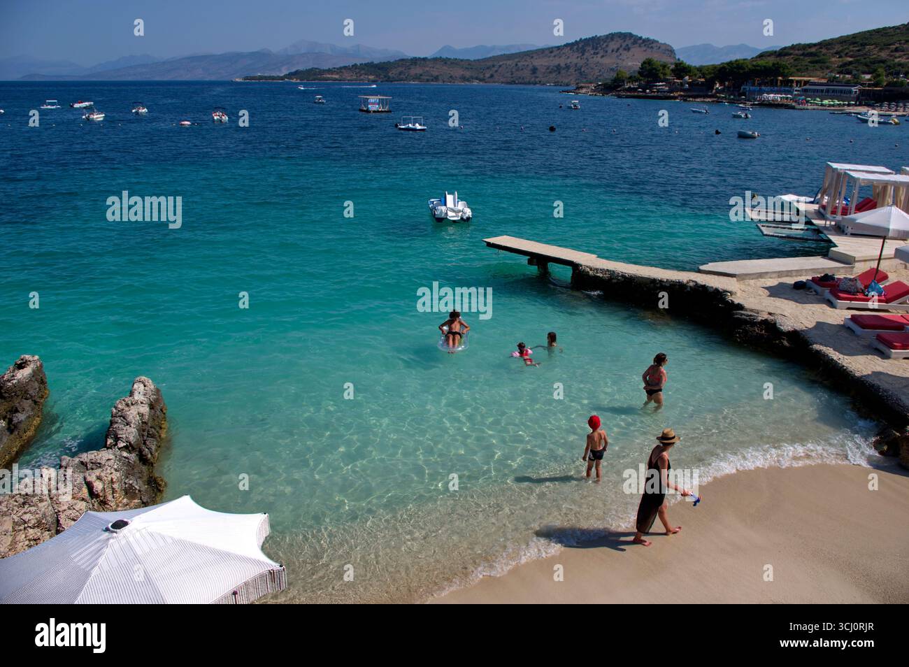 Pontile di prolungamento della spiaggia proteso sull'acqua limpida a Ksamil Stockfoto