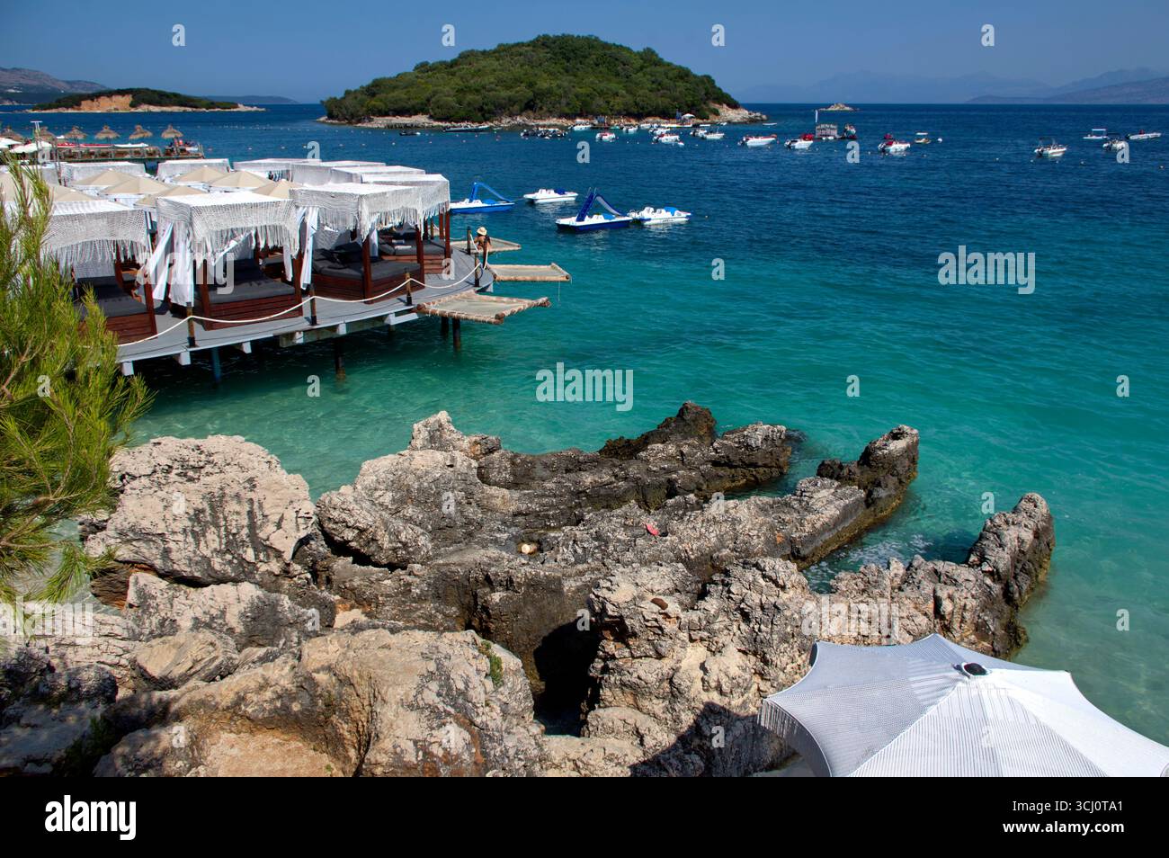 Pontile di prolungamento della spiaggia proteso sull'acqua limpida a Ksamil Stockfoto