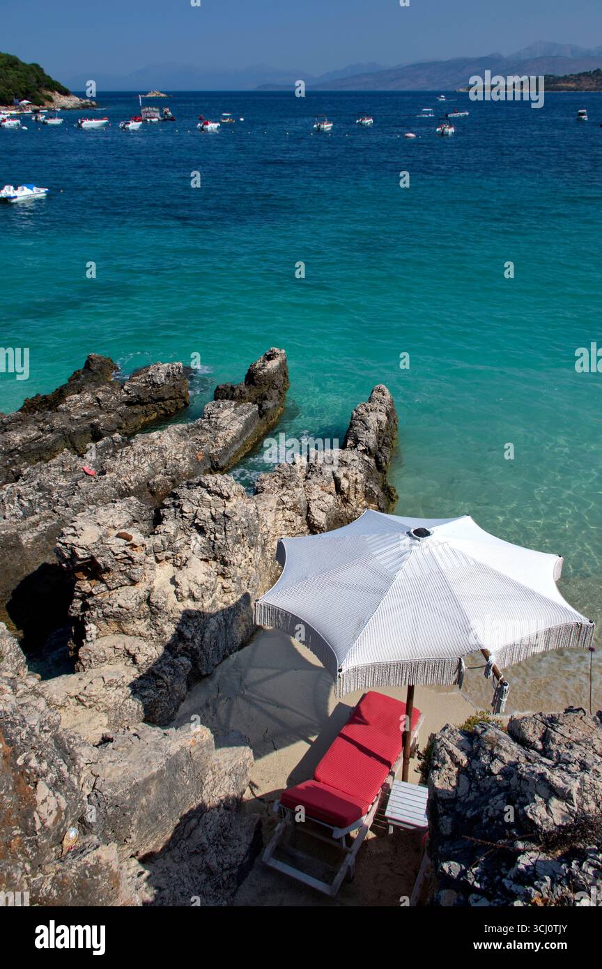 Ombrellone accanto ad uno scoglio in una spiaggia di Ksamil Stockfoto