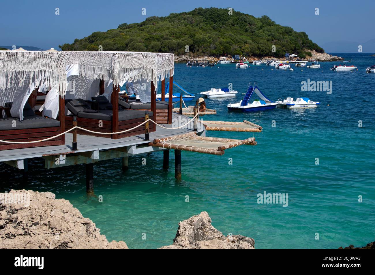 Pontile di prolungamento della spiaggia proteso sull'acqua limpida a Ksamil Stockfoto