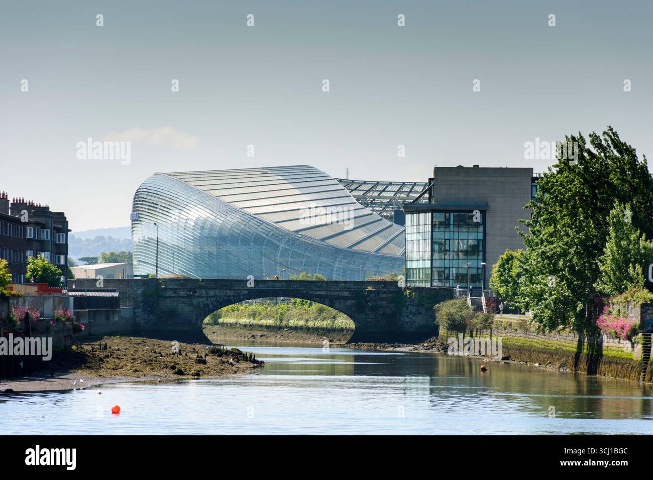 Der Fluss Dodder und die Ringsend-Brücke, mit dem Aviva-Stadion in der Ferne. Dublin, Irland. Stockfoto