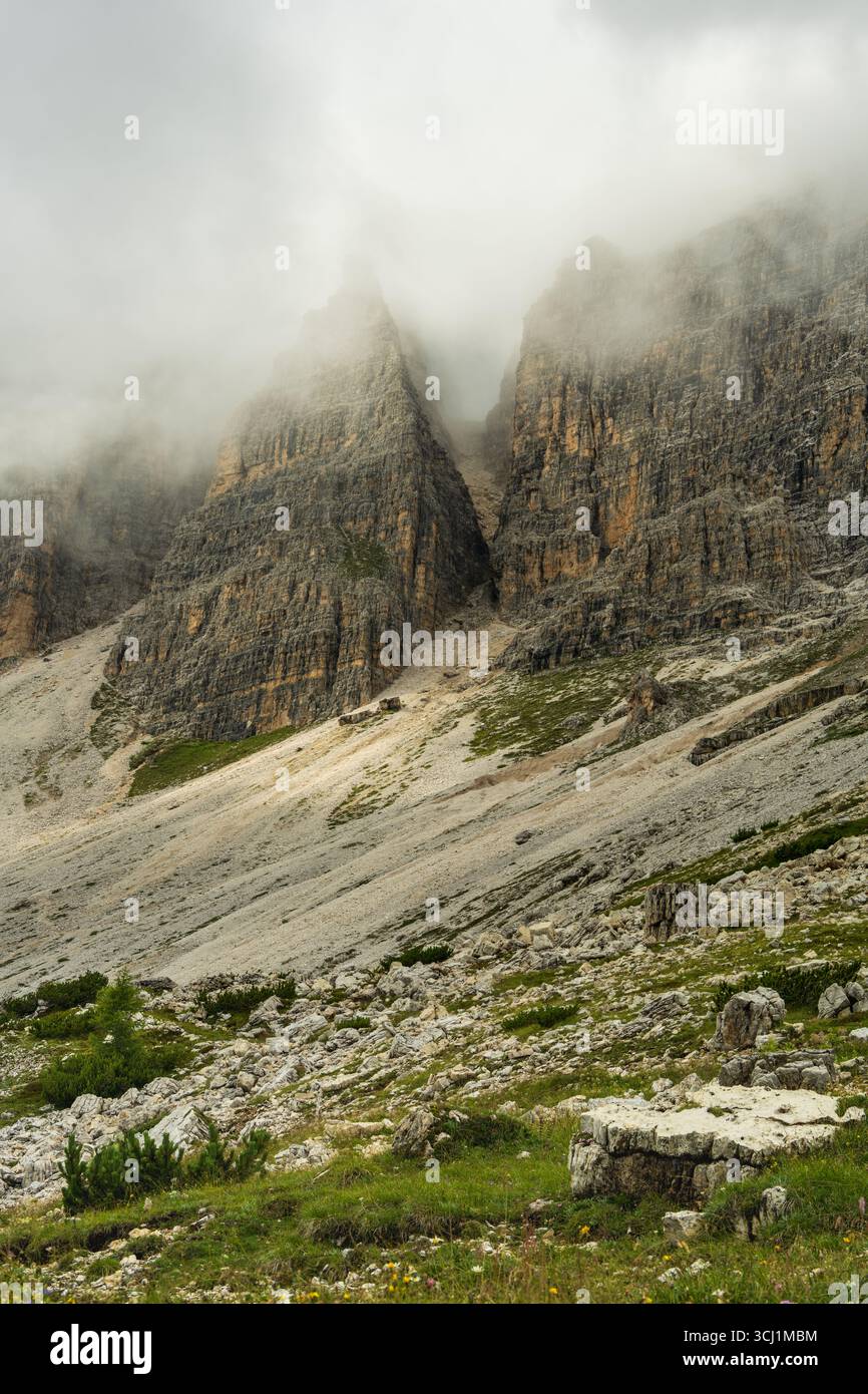 Dunkle Wolken und starker Nebel umgeben die felsigen Gipfel der Dolomiten. Eine kraftvolle und emotionale alpine Szene, ideal für dramatische, naturnahe visuelle Projekte. Stockfoto