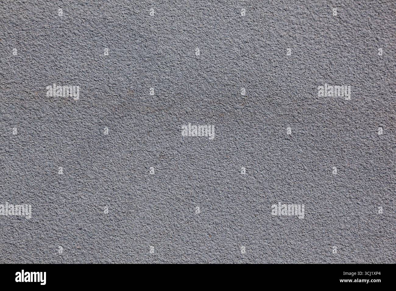 Textur aus grauem Asphalt und grauer feinkörniger Wandoberfläche, die einen neutralen industriellen Hintergrund mit subtilen, rauen Details schafft. Stockfoto