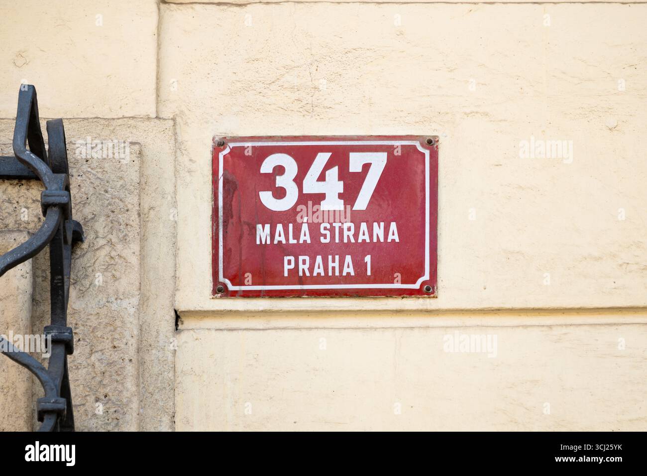 Rotes Adressschild Nr. 347 auf dem deutschen Botschaftsgebäude in Prag, Tschechien. Das rote System wurde durch ein neueres in Blau ersetzt. Stockfoto
