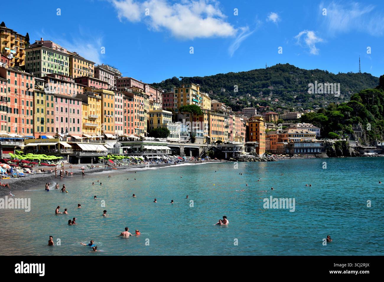 Die italienische Riviera Stadt Camogli mit ihren farbenfrohen Gebäuden und Badegästen, die an einem sonnigen Septembertag das Meer genießen. Stockfoto