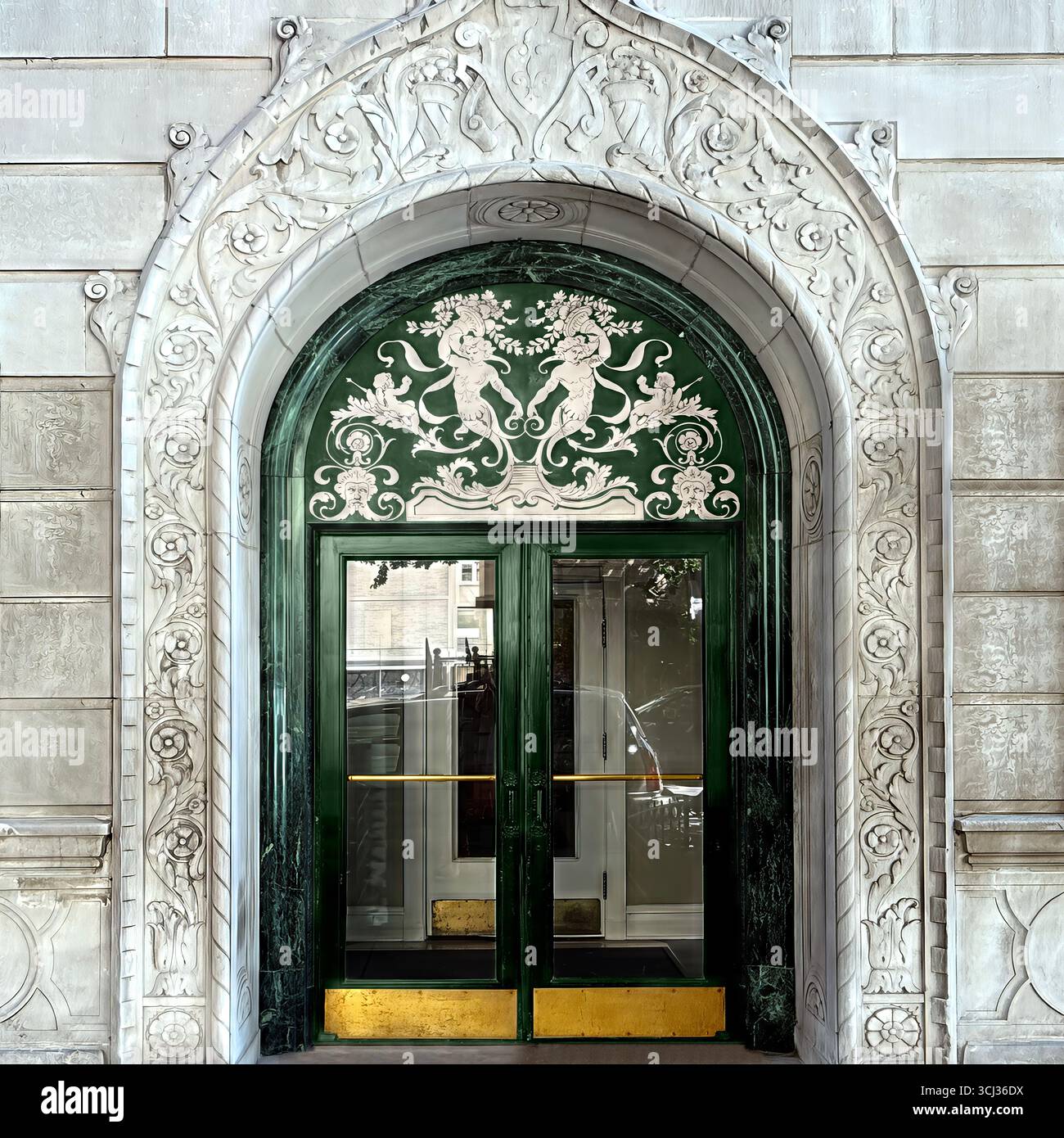 Eingang zum historischen Chicago-Gebäude mit kunstvollen Steinreliefs, die einen großen grünen Marmorbogen über Glastüren umrahmen. - Smartphone-aufgenommenes Stockfoto