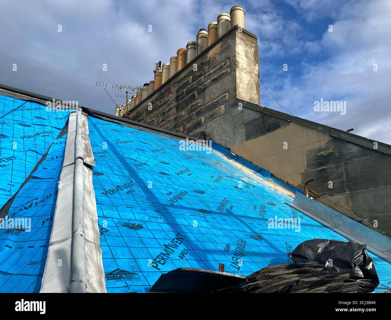 Das kommunale Dach repariert derzeit ein Gebäude in Edinburgh, installiert eine atmungsaktive wasserdichte Membranunterlage und erneuert die Sättigungsarbeiten Stockfoto