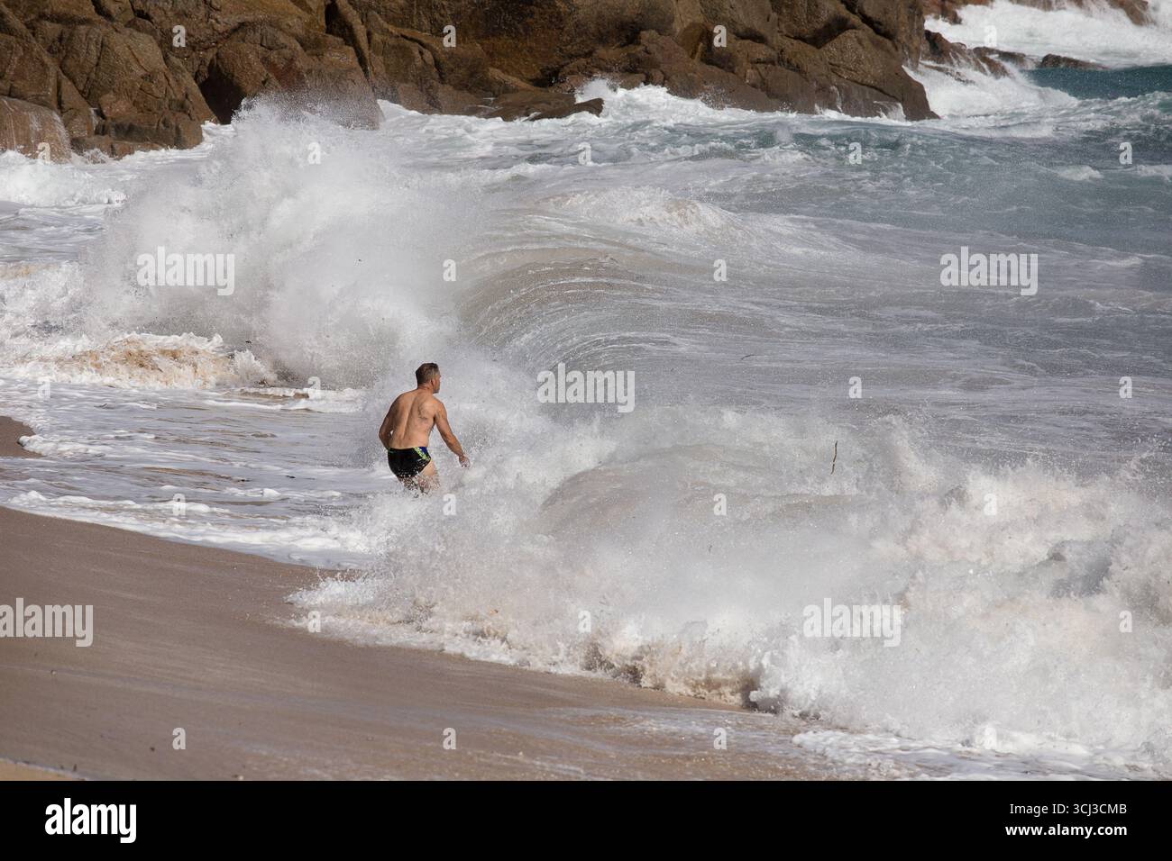 Schwimmer am Hochwasser-Strand Porthcurno Stockfoto