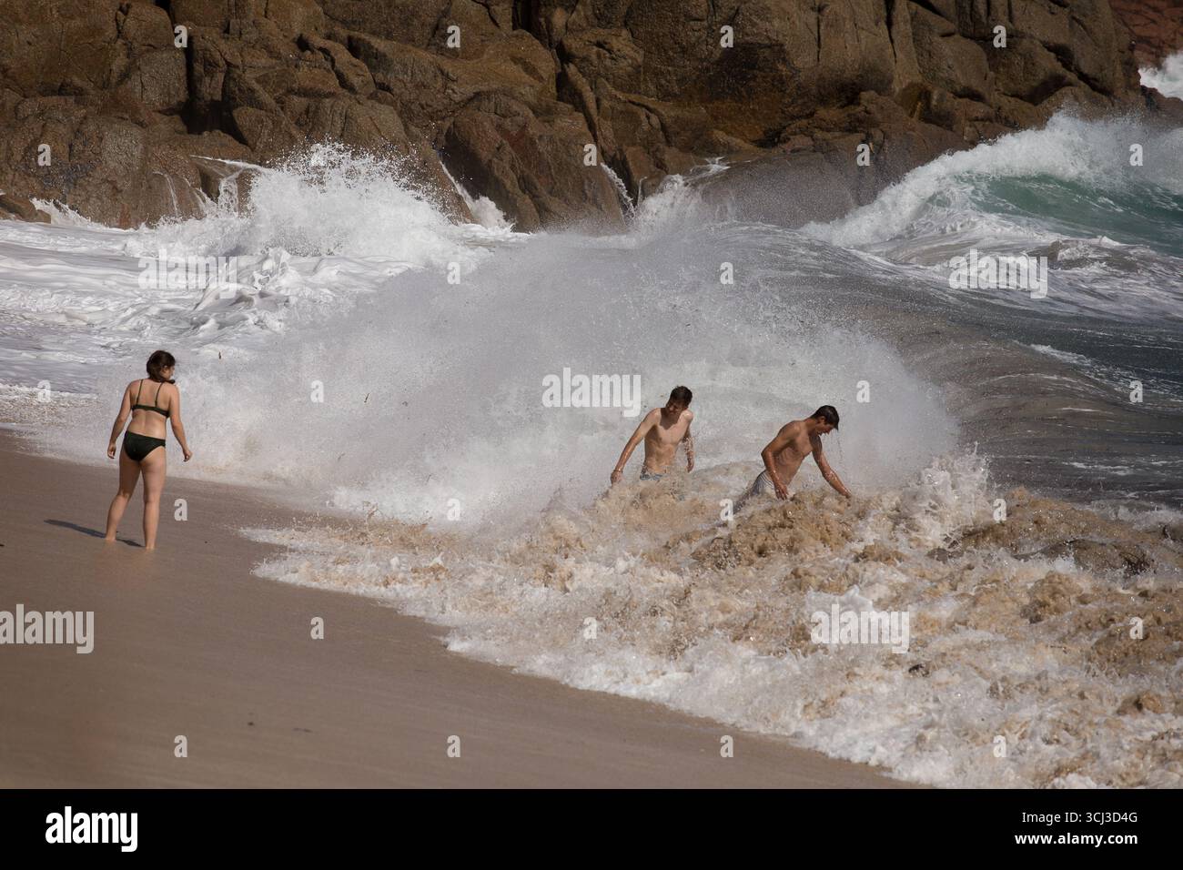 Schwimmer am Hochwasser-Strand Porthcurno Stockfoto