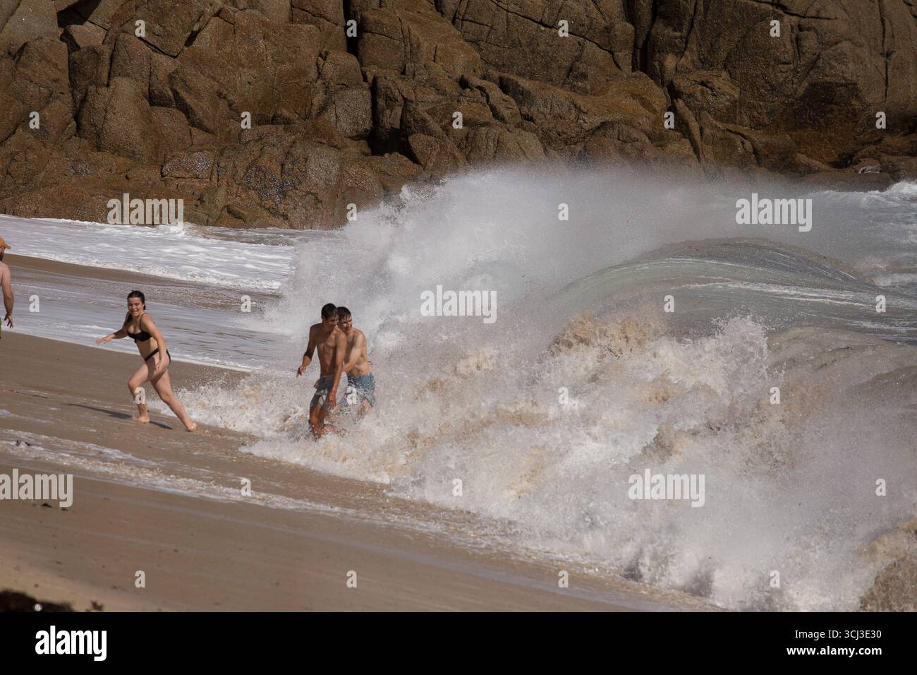 Schwimmer am Hochwasser-Strand Porthcurno Stockfoto