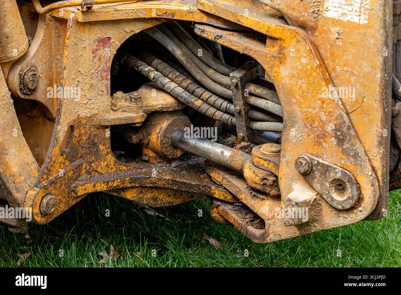 Baggerlader mit undichtem Schwenkzylinder. Wartung von Schwermaschinen, Reparatur von Baumaschinen und Servicekonzept. Stockfoto