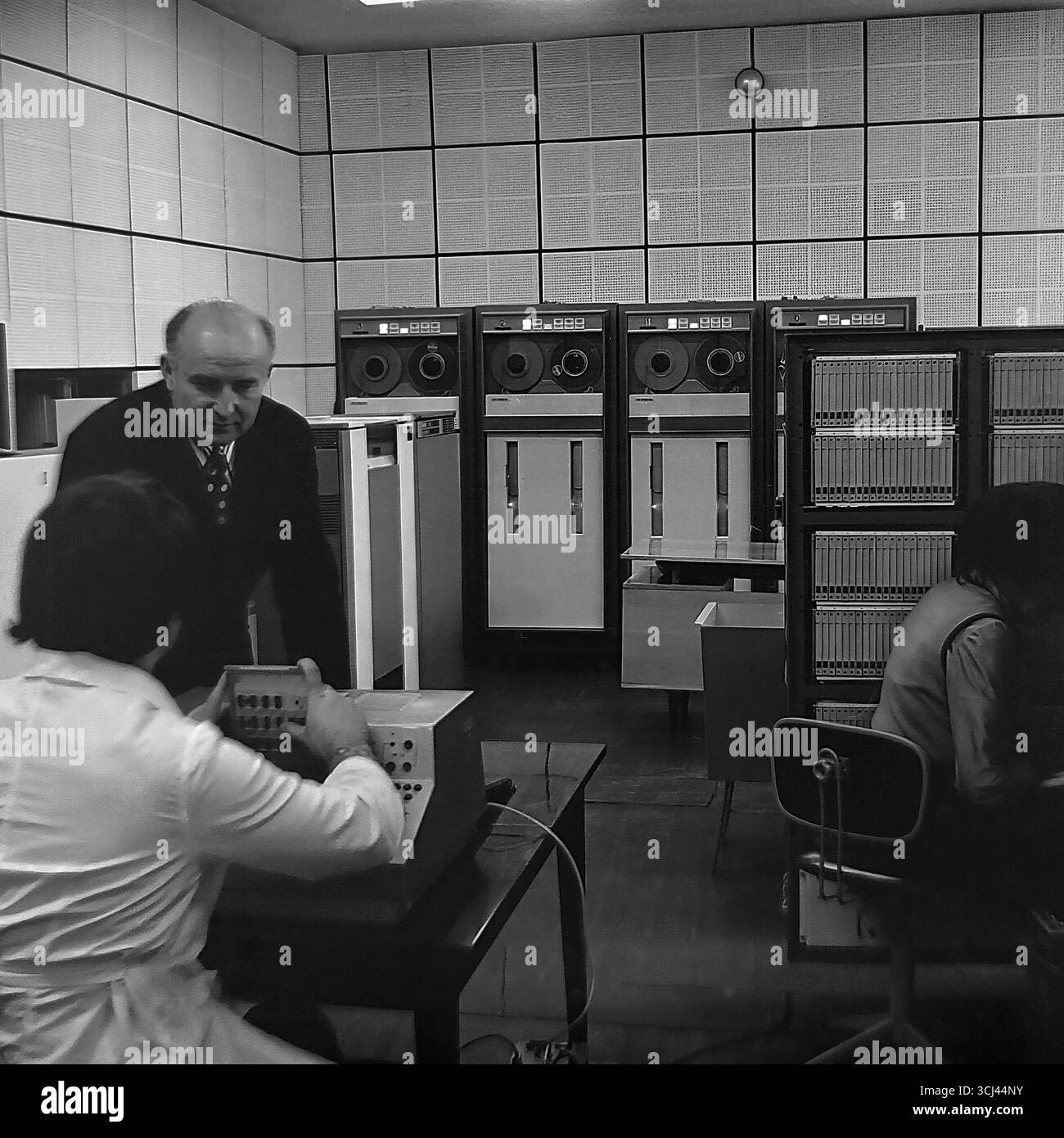 Ingenieure und Techniker warten im Januar 1978 einen großen sowjetischen Großrechner der es EVM-Serie in einem Rechenzentrum in einem Werk in Sloviansk. Das Archivfoto zeigt die Welt der Hochtechnologie in der Zeit der Stagnation und die Arbeit der wissenschaftlich-technischen Intelligenz. Diese Aufnahme, die das „Gehirn“ eines Industrieriesen erfasst, ist ein Symbol für das wissenschaftliche Potenzial und die friedliche Entwicklung des Donbass vor dem Krieg. Stockfoto