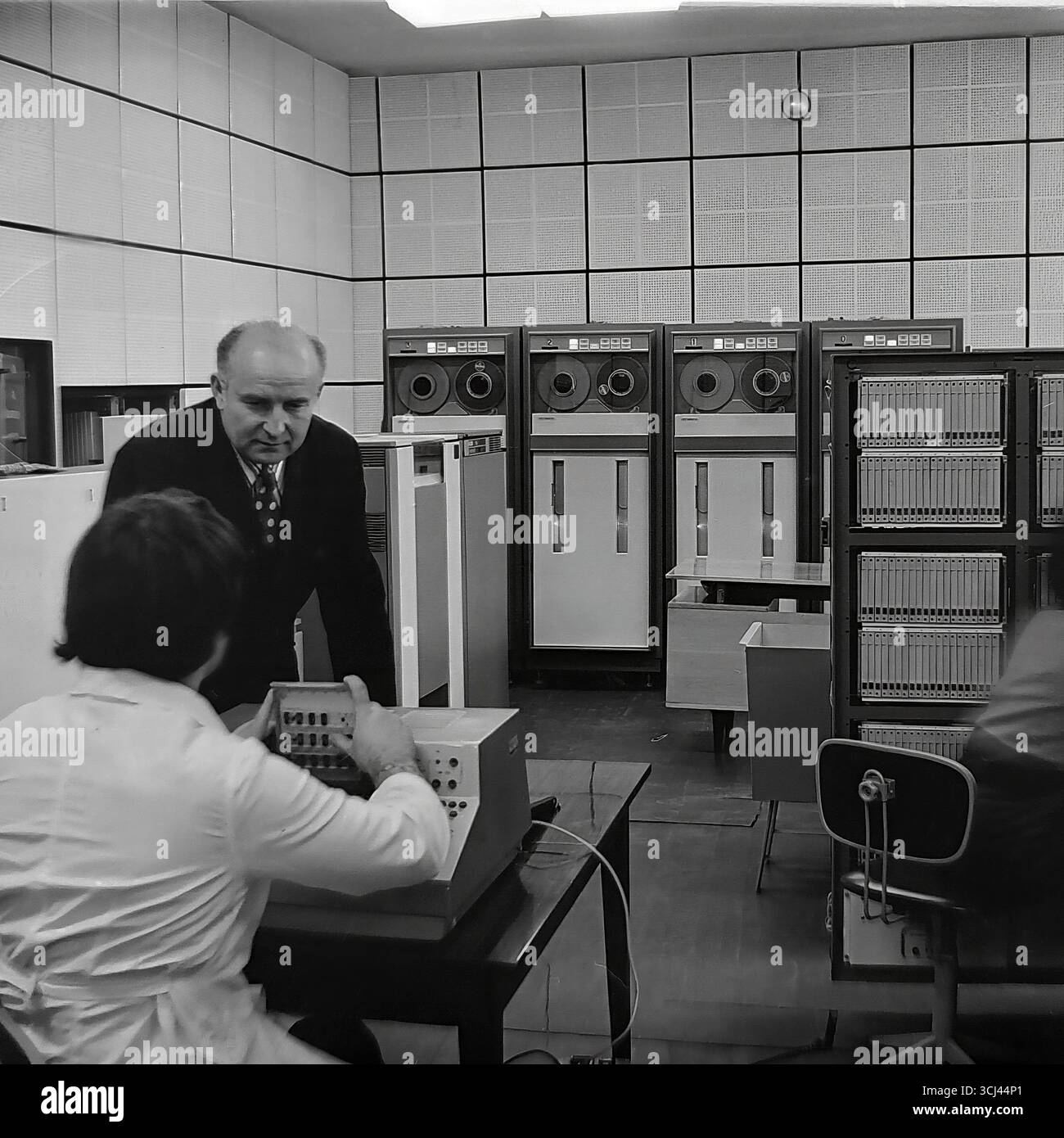 Ingenieure und Techniker warten im Januar 1978 einen großen sowjetischen Großrechner der es EVM-Serie in einem Rechenzentrum in einem Werk in Sloviansk. Das Archivfoto zeigt die Welt der Hochtechnologie in der Zeit der Stagnation und die Arbeit der wissenschaftlich-technischen Intelligenz. Diese Aufnahme, die das „Gehirn“ eines Industrieriesen erfasst, ist ein Symbol für das wissenschaftliche Potenzial und die friedliche Entwicklung des Donbass vor dem Krieg. Stockfoto