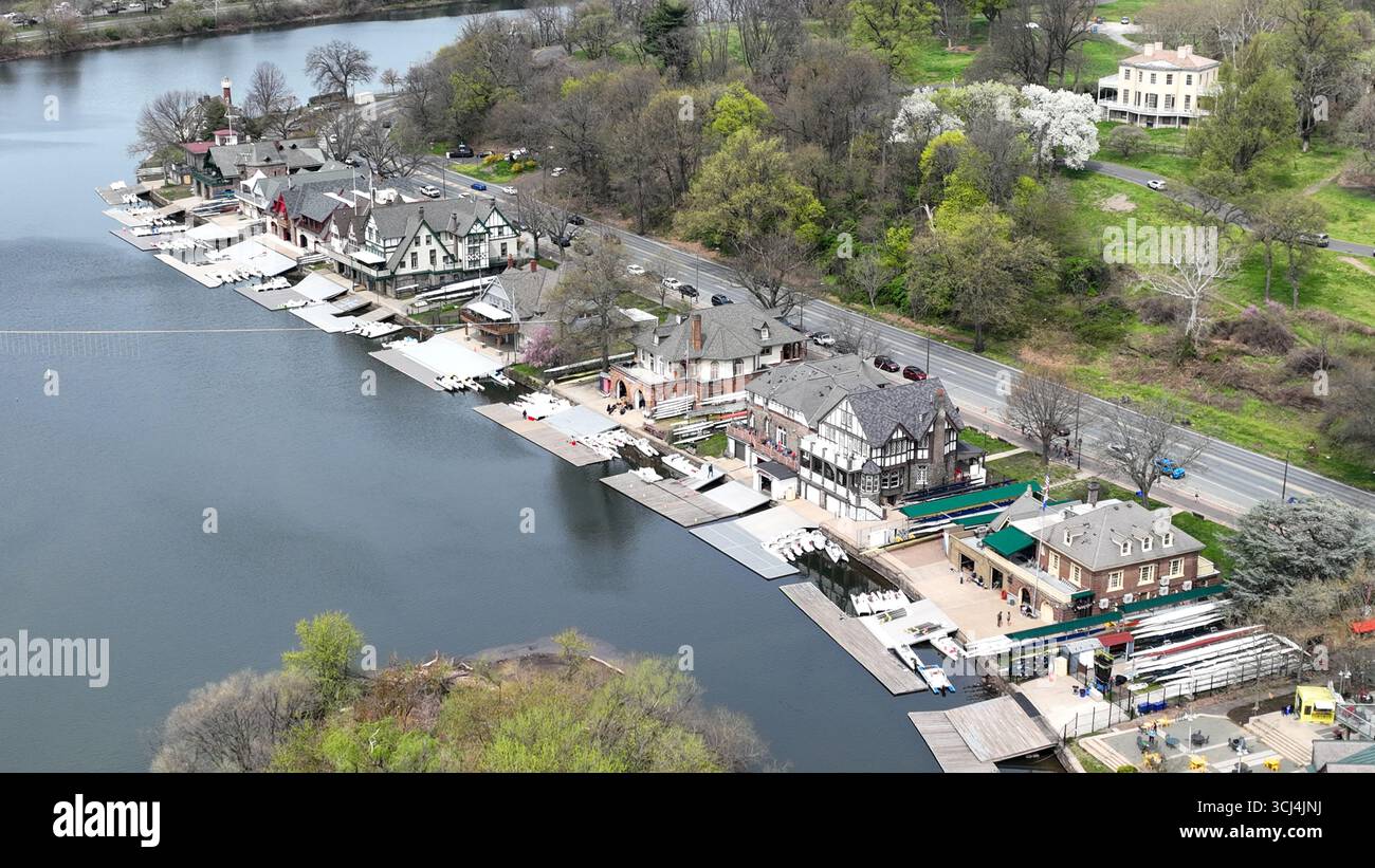 Aus der Vogelperspektive auf die historische Boathouse Row, die sich im ruhigen Wasser des Schuylkill River spiegelt, mit üppigen grünen Bäumen, die einen lebhaften Kontrast bilden, Philadelphia, Pennsylvania, USA. Stockfoto