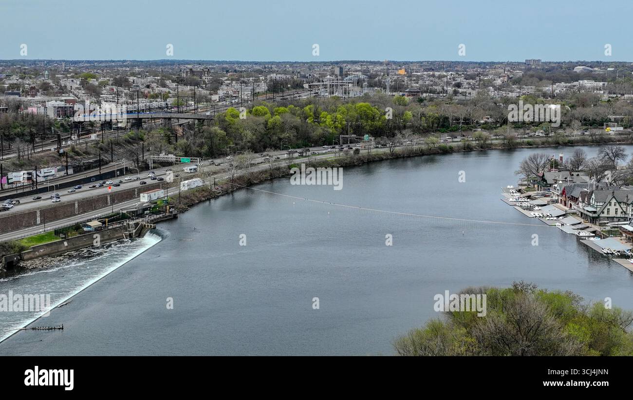 Blick aus der Vogelperspektive auf den Schuylkill River, der den Himmel reflektiert, umgeben von üppigem Grün und der markanten Boathouse Row, einem Wandteppich aus Natur und Architektur, Philadelphia, Pennsylvania, USA. Stockfoto