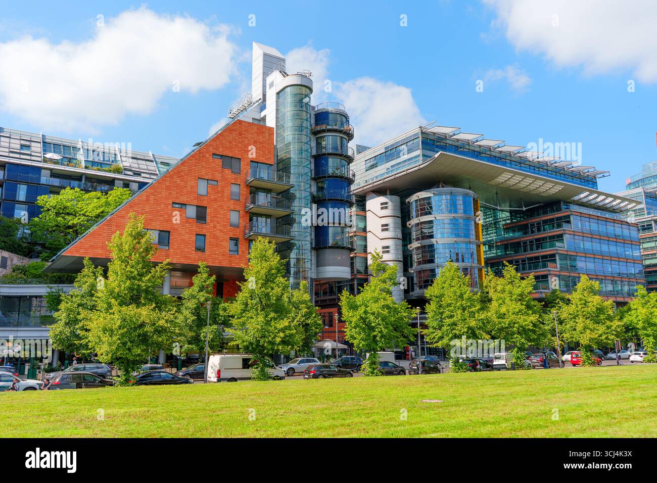 Berlin, Deutschland - 16. August 2025: Beeindruckende moderne Architektur des DaimlerChrysler-Komplexes mit Glas- und Ziegelbauwerken unter klarem blauem SK Stockfoto